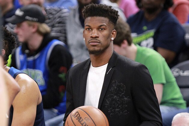 Injured Minnesota Timberwolves guard Jimmy Butler holds the game ball during a time out against the Houston Rockets in the third quarter of an NBA basketball game Sunday, March 18, 2018, in Minneapolis. (AP Photo/Andy Clayton-King)