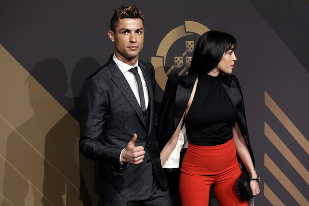 Real Madrid player Cristiano Ronaldo gestures as he arrives with his girlfriend Georgina Rodriguez for the Portuguese soccer federation awards ceremony Monday, March 19, 2018, in Lisbon. (AP Photo/Armando Franca)