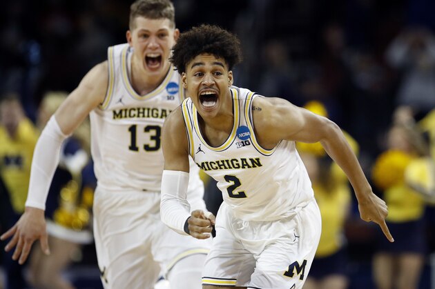 Michigan guard Jordan Poole (2) is chased by forward Moritz Wagner (13) after making a 3-point basket at the buzzer to win an NCAA men's college basketball tournament second-round game against Houston on Saturday, March 17, 2018, in Wichita, Kan. Michigan won 64-63. (AP Photo/Charlie Riedel)