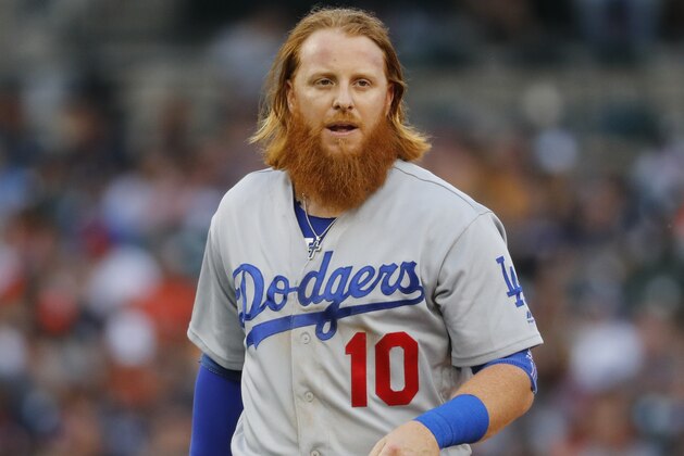Los Angeles Dodgers third baseman Justin Turner walks to the dugout against the Detroit Tigers in the second inning of a baseball game in Detroit, Friday, Aug. 18, 2017. (AP Photo/Paul Sancya)