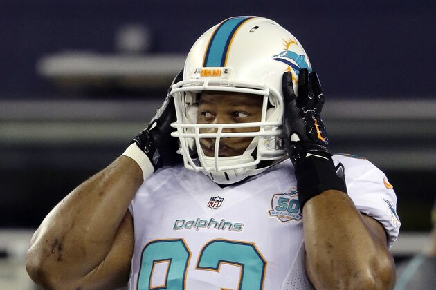 Miami Dolphins defensive tackle Ndamukong Suh adjusts his helmet before an NFL football game against the New England Patriots, Thursday, Oct. 29, 2015, in Foxborough, Mass. (AP Photo/Steven Senne)