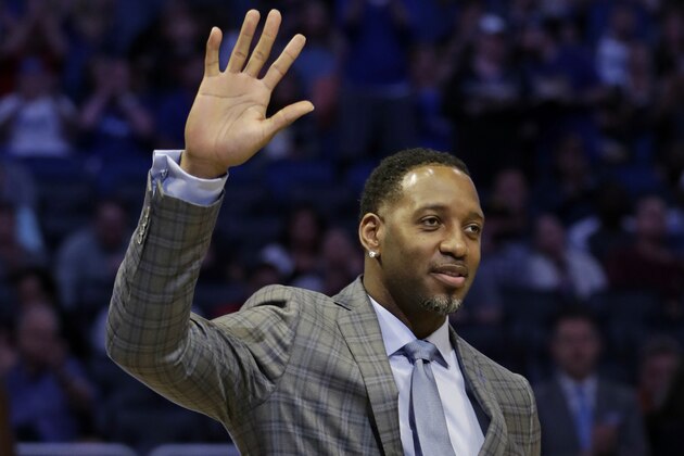 Former NBA and Orlando Magic player Tracy McGrady waves to fans after he was inducted into the Magic Hall of Fame during a ceremony in the first half of an NBA basketball game between the Orlando Magic and the Toronto Raptors, Tuesday, March 20, 2018, in Orlando, Fla. (AP Photo/John Raoux)