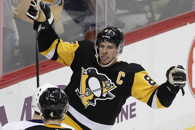 Pittsburgh Penguins' Sidney Crosby (87) celebrates his winning goal in overtime of an NHL hockey game against the New York Islanders in Pittsburgh, Saturday, March 3, 2018. (AP Photo/Gene J. Puskar)