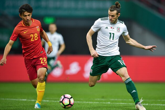 Gareth Bale (R) of Wales competes for the ball with Wang Shenchao of China during their China Cup International Football Championship Semi-final match in Nanning in China's southern Guangxi region on March 22, 2018. / AFP PHOTO / - / China OUT        (Photo credit should read -/AFP/Getty Images)
