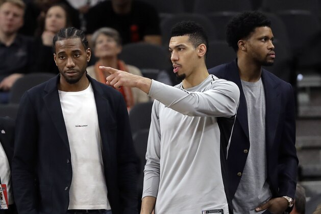 San Antonio Spurs guard Danny Green, center, stands at the bench with injured teammates Kawhi Leonard, left, and Rudy Gay, right, during the second half of an NBA basketball game against the Indiana Pacers, Sunday, Jan. 21, 2018, in San Antonio. Indiana won 94-86. (AP Photo/Eric Gay)