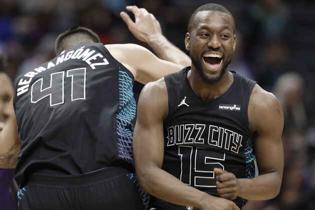 Charlotte Hornets' Kemba Walker (15) celebrates with Willy Hernangomez (41) during the second half of an NBA basketball game against the Memphis Grizzlies in Charlotte, N.C., Thursday, March 22, 2018. (AP Photo/Chuck Burton)