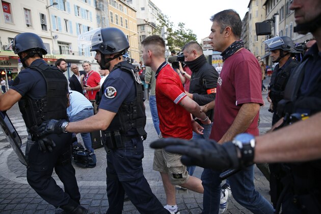 A man is apprehended by French police in downtown Marseille, France, Friday, June 10, 2016.  Some minor scuffles on Friday and the brief clashes late Thursday revived bitter memories of days of bloody fighting in this Mediterranean port city between England hooligans, Tunisia fans and locals of North African origin during the World Cup in 1998, and raised fears of more violence ahead of Saturday's European Championship match between England and Russia at the Stade Velodrome.(AP Photo/Ariel Schalit)