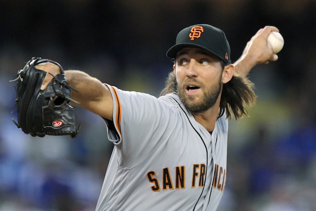 FILE - In this Sept. 23, 2017 file photo, San Francisco Giants starting pitcher Madison Bumgarner throws during a baseball game against the Los Angeles Dodgers in Los Angeles. Madison Bumgarner's $12-million option for the 2018 season has been exercised by the San Francisco Giants, who are determined to keep a talented rotation intact as the club looks to bounce back from a last-place season. (AP Photo/Mark J. Terrill, File)