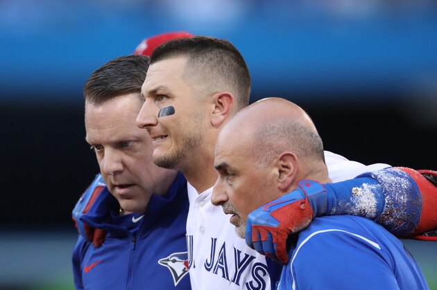 TORONTO, ON - JULY 28: Troy Tulowitzki #2 of the Toronto Blue Jays is helped off the field by trainers George Poulis and Mike Frostad after injuring his ankle in the third inning during MLB game action against the Los Angeles Angels of Anaheim at Rogers Centre on July 28, 2017 in Toronto, Canada. (Photo by Tom Szczerbowski/Getty Images)