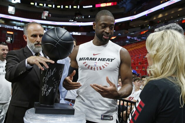 Miami Heat guard Dwyane Wade (3) speaks with a fan during warmups before play against the New York Knicks in an NBA basketball game, Wednesday, March 21, 2018, in Miami. Wade did not play in the 119-98 Heat win. (AP Photo/Joe Skipper)