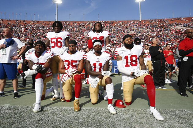 LOS ANGELES, CA - DECEMBER 31: Eli Harold #57, Eric Reid #35, Marquise Goodwin #11 and Louis Murphy #18 of the San Francisco 49ers kneel during the anthem as Reuben Foster #56 and Adrian Colbert #38 stand in solidarty, prior to the game against the Los Angeles Rams at Los Angeles Memorial Coliseum on December 31, 2017 in Los Angeles, California. The 49ers defeated the Rams 34-13. (Photo by Michael Zagaris/San Francisco 49ers/Getty Images)