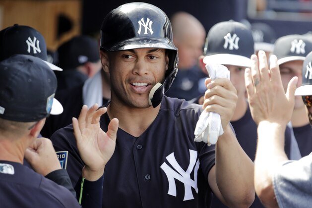 FILE - In this March 2, 2018, file photo, New York Yankees' Giancarlo Stanton is congratulated after scoring on a single by Didi Gregorius during the fifth inning of a the team's baseball spring training game against the Atlanta Braves in Tampa, Fla. After last season the Yankees added the mightiest slugger in the major leagues, Stanton. (AP Photo/Lynne Sladky, File)