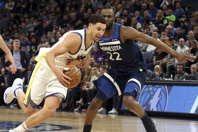 Golden State Warriors' Klay Thompson drives around Minnesota Timberwolves' Andrew Wiggins in the second half of an NBA basketball game Sunday, March 11, 2018, in Minneapolis. The Timberwolves won 109-103. Thompson scored 21 points and Wiggins scored 23. (AP Photo/Jim Mone)