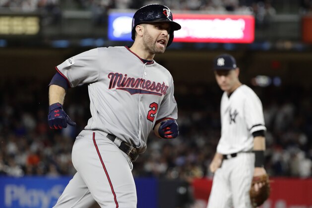 Minnesota Twins' Brian Dozier runs past New York Yankees third baseman Todd Frazier after hitting a home run during the first inning of the American League wild-card baseball playoff game Tuesday, Oct. 3, 2017, in New York. (AP Photo/Frank Franklin II)