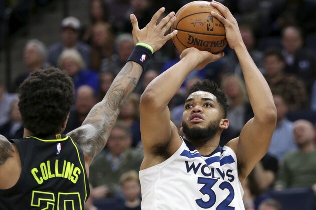 Minnesota Timberwolves forward Karl-Anthony Towns (32) shoots as Atlanta Hawks forward John Collins (20) defends during the third quarter of an NBA basketball game Wednesday, March 28, 2018, in Minneapolis. The Timberwolves defeated the Hawks 126-114. Towns had a career-high 56 points. (AP Photo/Andy Clayton-King)