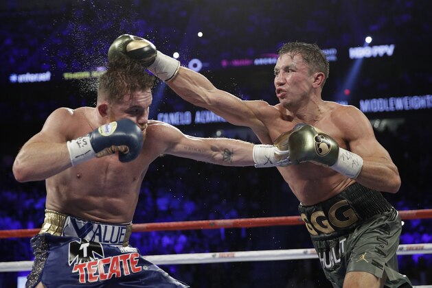 Gennady Golovkin, right, connects with a right to Canelo Alvarez during a middleweight title fight Sunday, Sept. 17, 2017, in Las Vegas. (AP Photo/John Locher)