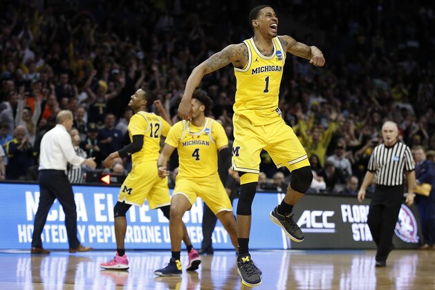 Michigan guard Charles Matthews (1), guard Muhammad-Ali Abdur-Rahkman (12) and forward Isaiah Livers (4) celebrate after Michigan defeated Florida State 58-54 in an NCAA men's college basketball tournament regional final Saturday, March 24, 2018, in Los Angeles. (AP Photo/Alex Gallardo)