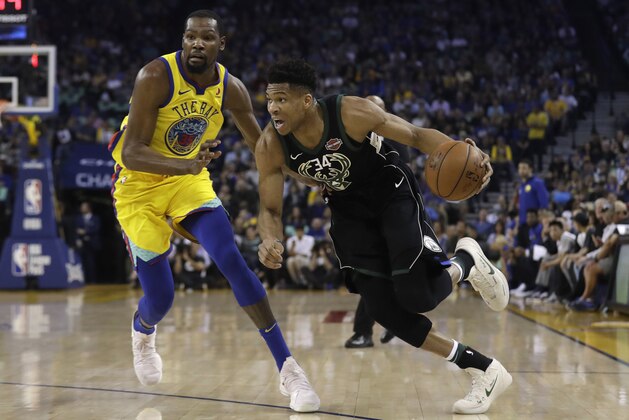 Milwaukee Bucks' Giannis Antetokounmpo, right, drives past Golden State Warriors' Kevin Durant during the first half of an NBA basketball game Thursday, March 29, 2018, in Oakland, Calif. (AP Photo/Marcio Jose Sanchez)