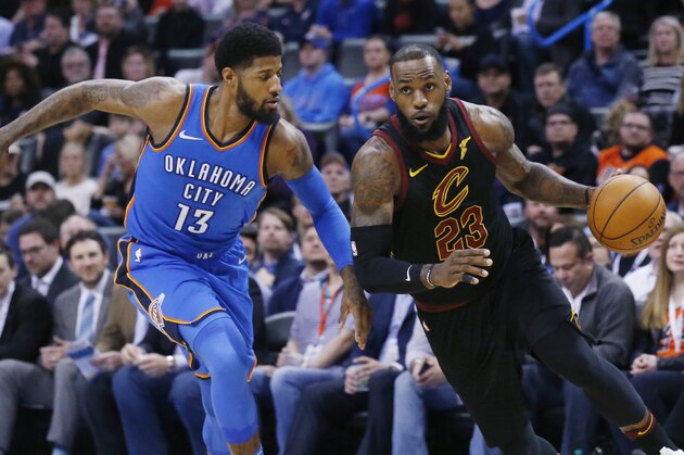 Cleveland Cavaliers forward LeBron James (23) drives past Oklahoma City Thunder forward Paul George (13) during the first half of an NBA basketball game in Oklahoma City, Tuesday, Feb. 13, 2018. (AP Photo/Sue Ogrocki)