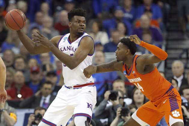 Kansas' Udoka Azubuike, left, looks to pass around Clemson's Elijah Thomas during the first half of a regional semifinal game in the NCAA men's college basketball tournament Friday, March 23, 2018, in Omaha, Neb. (AP Photo/Charlie Neibergall)