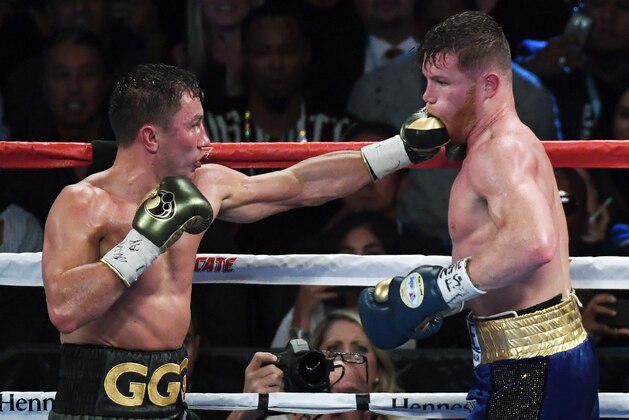 LAS VEGAS, NV - SEPTEMBER 16:  Gennady Golovkin (L) throws a left at Canelo Alvarez in the 12th round of their WBC, WBA and IBF middleweight championship bout at T-Mobile Arena on September 16, 2017 in Las Vegas, Nevada. The boxers fought to a draw and Golovkin retained his titles.  (Photo by Ethan Miller/Getty Images)
