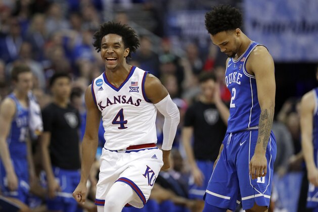 Kansas' Devonte' Graham, left, celebrates as he runs past Duke's Gary Trent Jr. in the final seconds of overtime of a regional final game in the NCAA men's college basketball tournament Sunday, March 25, 2018, in Omaha, Neb. Kansas won 85-81 in overtime. (AP Photo/Charlie Neibergall)