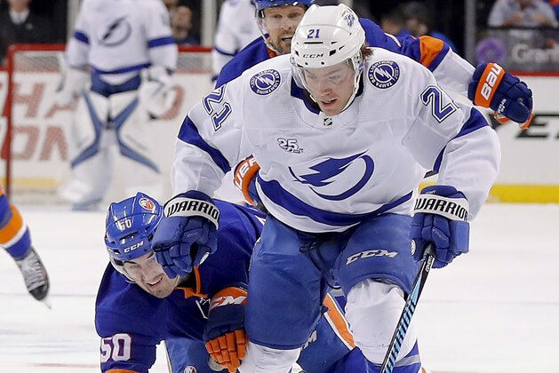Tampa Bay Lightning center Brayden Point (21) is tripped by New York Islanders defenseman Adam Pelech (50) during the first period of an NHL hockey game Thursday, March 22, 2018, in New York. (AP Photo/Julie Jacobson)