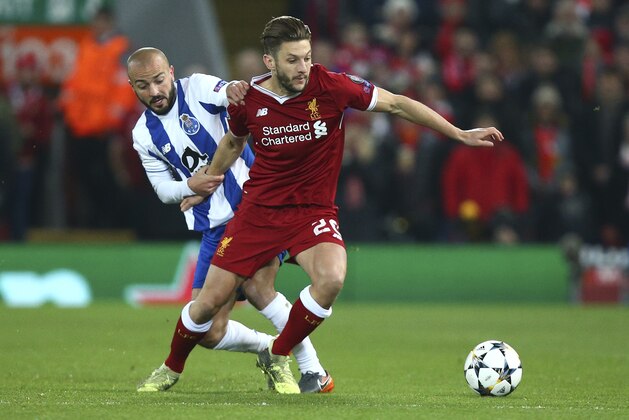 Porto's Andre Andre, left, fights for the ball with Liverpool's Adam Lallana during the Champions League round of 16, second leg, soccer match between Liverpool and FC Porto at Anfield Stadium, Liverpool, England, Tuesday March 6, 2018. (AP Photo/Dave Thompson)