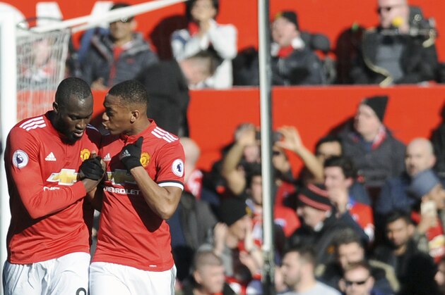 Manchester United's Romelu Lukaku, left, speaks with Anthony Martial after scoring his side's opening goal during the English Premier League soccer match between Manchester United and Chelsea at the Old Trafford stadium in Manchester, England, Sunday, Feb. 25, 2018. (AP Photo/Rui Vieira)