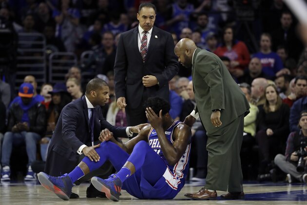 Philadelphia 76ers' Joel Embiid, center, lies not he court after an injury during the first half of an NBA basketball game against the New York Knicks, Wednesday, March 28, 2018, in Philadelphia. (AP Photo/Matt Slocum)