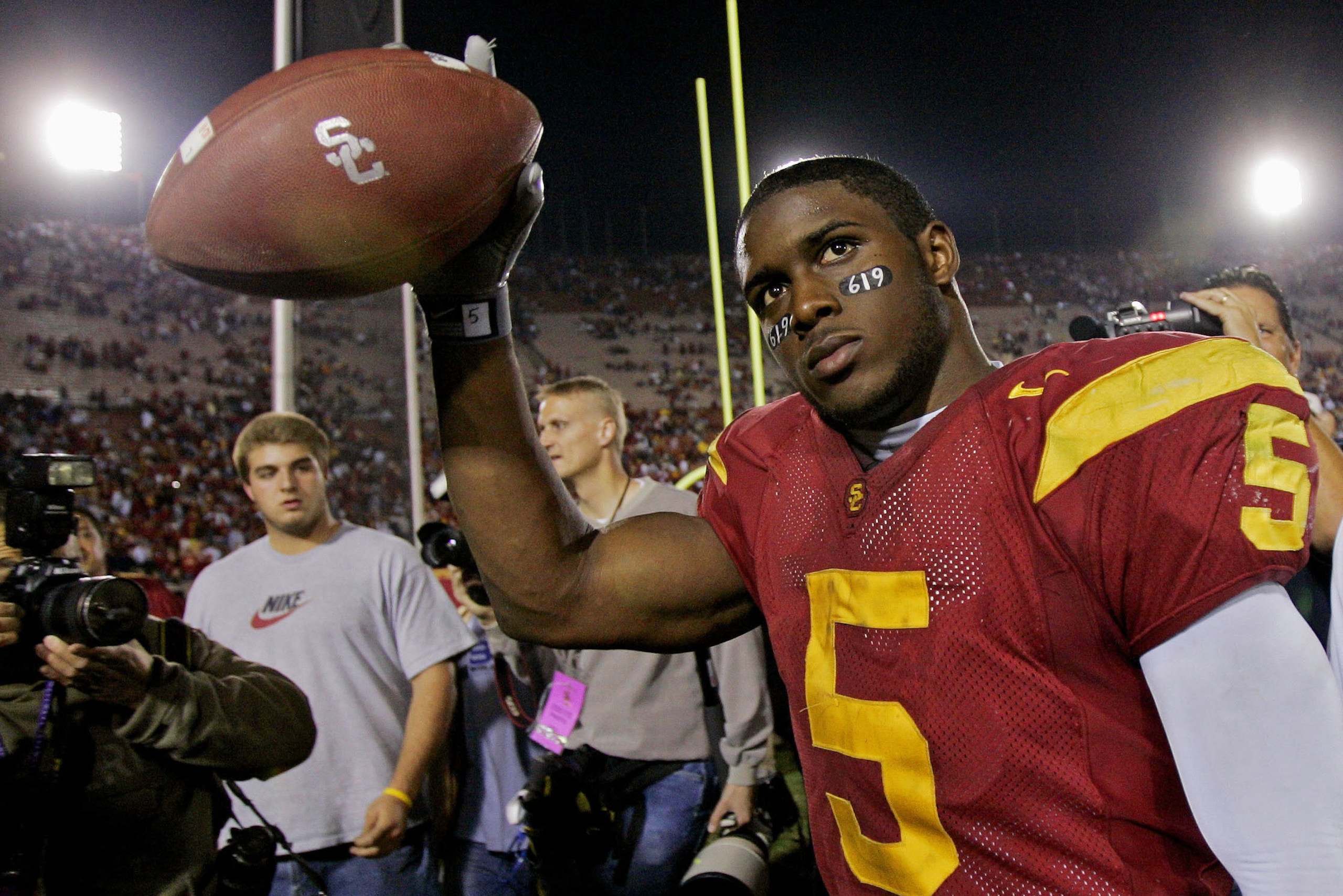 FILE - In this Nov. 19, 2005, file photo, Southern California tail back Reggie Bush walks off the field holding the game ball after the Trojans defeated Fresno State, 50-42, at the Los Angeles Coliseum. USC set a record by going 33 straight polls as No. 1 from 2003-05. The Trojans weren’t just the best team in college football, they were also arguably the coolest, with the charismatic, laid-back Carroll leading stars like quarterback Matt Leinart and running back Reggie Bush to victory after victory.  (AP Photo/Kevork Djansezian, File)