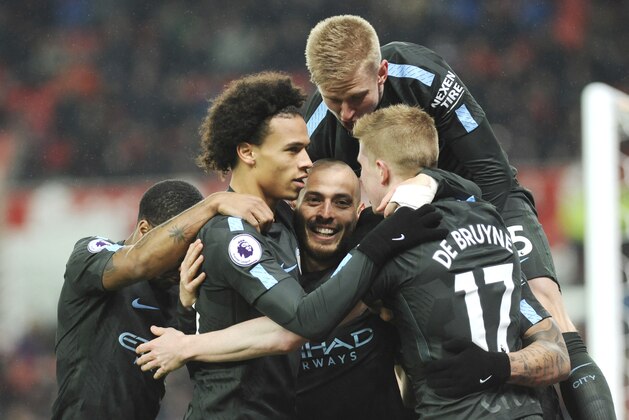 Manchester City's David Silva, centre, celebrates with team mates after scoring his second goal during the English Premier League soccer match between Stoke City and Manchester City at the Bet 365 Stadium in Stoke on Trent, England, Monday, March 12, 2018. (AP Photo/Rui Vieira)