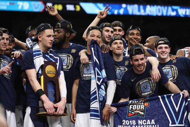 SAN ANTONIO, TX - APRIL 02:  Donte DiVincenzo #10 of the Villanova Wildcats holds the trophy while celebrating with teammates after defeating the Michigan Wolverines during the 2018 NCAA Men's Final Four National Championship game at the Alamodome on April 2, 2018 in San Antonio, Texas. Villanova defeated Michigan 79-62.  (Photo by Ronald Martinez/Getty Images)