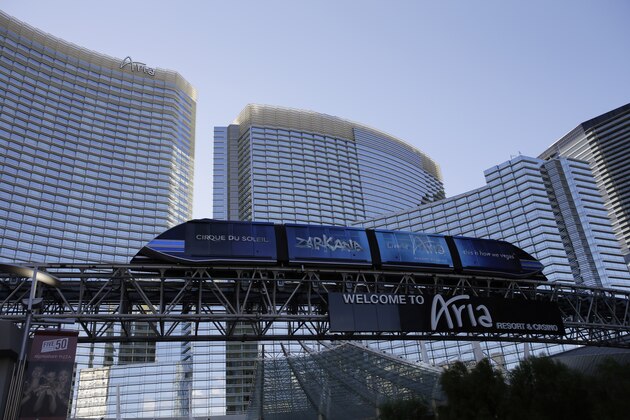 In this Thursday, Aug. 14, 2014 photo, a tram travels by the front of the Aria Resort & Casino, in Las Vegas. This year, hotels will take in a record $2.25 billion in revenue from fees and surcharges, 6 percent more than in 2013 and nearly double that of a decade ago, according to a new study. Nearly half of the increase can be attributed to new surcharges and hotels increasing the amounts of existing fees. (AP Photo/John Locher)