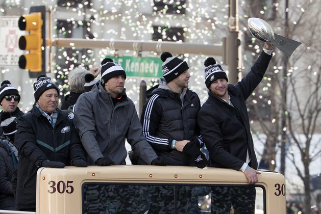 Philadelphia Eagles NFL football team quarterback Carson Wentz, right, holds up the Vince Lombardi trophy as he rides with fellow quarterbacks Nate Sudfeld, center right, Nick Foles, center left, and team owner Jeffrey Lurie, left, during a Super Bowl victory parade, Thursday, Feb. 8, 2018, in Philadelphia. The Eagles beat the New England Patriots 41-33 in Super Bowl 52. (AP Photo/Christopher Szagola)