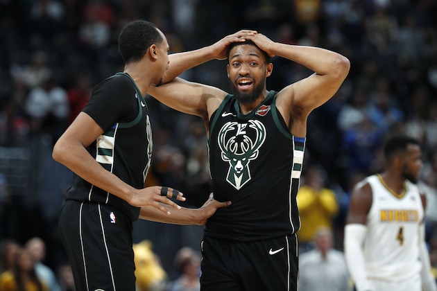 Milwaukee Bucks center John Henson, left, consoles forward Jabari Parker after he missed a shot and did not get a foul call against the Denver Nuggets, at the end of overtime of an NBA basketball game Sunday, April 1, 2018, in Denver. The Nuggets won 128-125. (AP Photo/David Zalubowski)