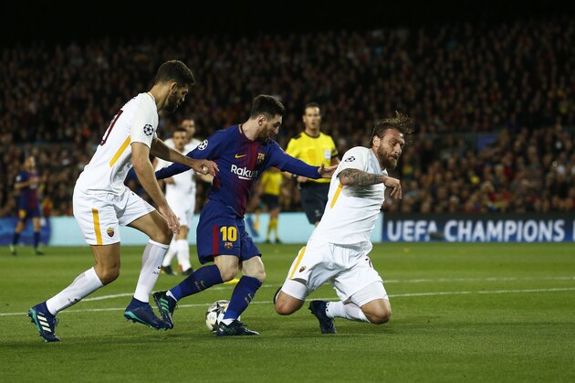 Barcelona's Lionel Messi, center is challenges by Roma's Federico Fazio, left,and his teammate Daniele de Rossi, right, during a Champions League quarter-final, first leg soccer match between FC Barcelona and Roma at the Camp Nou stadium in Barcelona, Spain, Wednesday, April 4, 2018.(AP Photo/ Manu Fernandez)