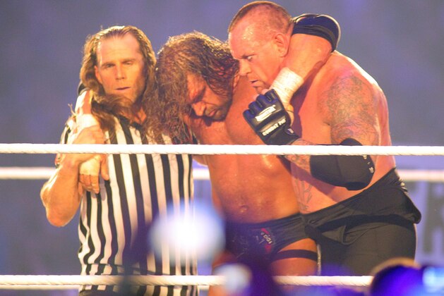 COMMERCIAL IMAGE - In this photograph taken by AP Images for WWE, Hall of famer Shawn Michaels, left, and Undertaker who brings his un-defeated record to 20-0, right, take H.H.H. from the ring during WrestleMania XXVIII in Sun Life Stadium on Sunday, April 1, 2012 in Miami. (Marc Serota/AP Images for WWE)