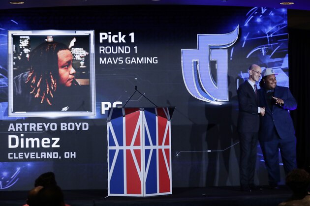NBA Commissioner Adam Silver, left, poses for photographs with the number 1 overall pick, Artreyo Boyd, at the NBA 2K League draft Wednesday, April 4, 2018, in New York. Launching in 2018, the league will feature the best NBA 2K players in the world and will draft players to compete as unique characters in 5-on-5 play against the other teams in a mix of regular-season games, tournaments and playoffs. (AP Photo/Frank Franklin II)