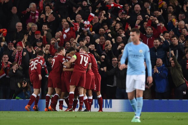 Liverpool's Egyptian midfielder Mohamed Salah celebrates with teammates scoring the team's opening goal during the UEFA Champions League first leg quarter-final football match between Liverpool and Manchester City, at Anfield stadium in Liverpool, north west England on April 4, 2018. / AFP PHOTO / PAUL ELLIS        (Photo credit should read PAUL ELLIS/AFP/Getty Images)