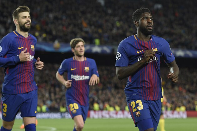 Barcelona's French defender Samuel Umtiti and teammates celebrate Roma's second own-goal during the UEFA Champions League quarter-final first leg football match between FC Barcelona and AS Roma at the Camp Nou Stadium in Barcelona on April 4, 2018. / AFP PHOTO / LLUIS GENE        (Photo credit should read LLUIS GENE/AFP/Getty Images)