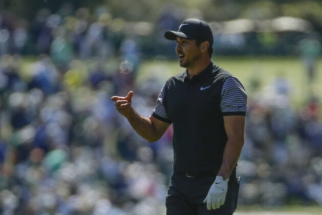 Jason Day, of Australia, looks to his ball that landed in a fan's cup of beer during the first round at the Masters golf tournament Thursday, April 5, 2018, in Augusta, Ga. (AP Photo/Chris Carlson)