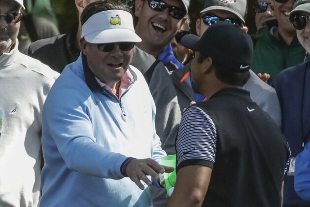 A fan gives Jason Day, of Australia, his ball back after drinking the beer from the cup that it landed in landed in during the first round at the Masters golf tournament Thursday, April 5, 2018, in Augusta, Ga. (AP Photo/Chris Carlson)