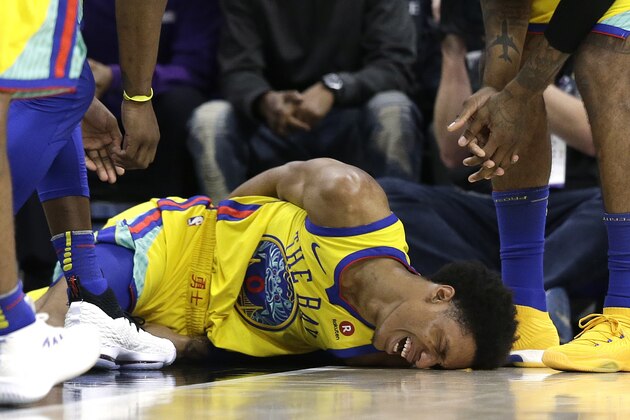 Golden State Warriors guard Patrick McCaw lays on the court in pain after falling hard to the floor late in the third quarter following a Flagrant 1 foul by Sacramento Kings's Vince Carter in an NBA basketball game Saturday, March 31, 2018, in Sacramento, Calif. McCaw was taken off the court on a stretcher. The Warriors won 112-96. (AP Photo/Rich Pedroncelli)