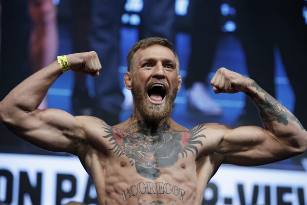 Conor McGregor poses on the scale during a weigh-in Friday, Aug. 25, 2017, in Las Vegas. McGregor is scheduled to fight Floyd Mayweather Jr. in a boxing bout Saturday (AP Photo/John Locher)