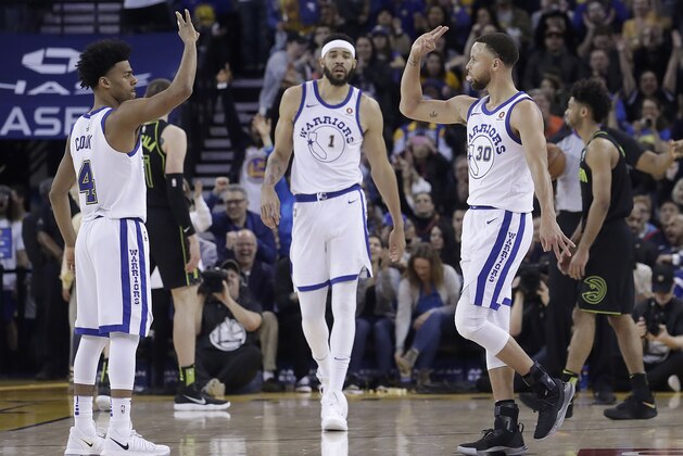 Golden State Warriors guard Stephen Curry (30) celebrates after scoring, with guard Quinn Cook (4) and center JaVale McGee (1) during the second half of an NBA basketball game against the Atlanta Hawks in Oakland, Calif., Friday, March 23, 2018. (AP Photo/Jeff Chiu)