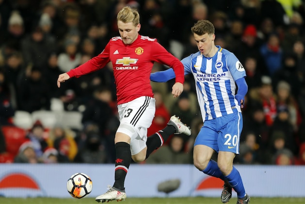 Manchester United's Luke Shaw, left, is challenged by Brighton's Solly March during the English FA Cup quarterfinal soccer match between Manchester United and Brighton, at the Old Trafford stadium in Manchester, England, Saturday, March 17, 2018. (AP Photo/Frank Augstein)