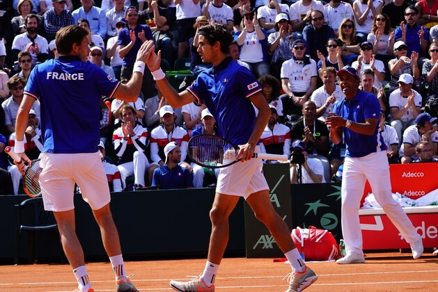 France's Nicolas Mahut (L), compatriot France's Pierre-Hugues Herbert and coach Yannick Noah celebrate a point against Italy's Fabio Fognini and Italy's Simone Bolelli during the Davis Cup quarter-final doubles tennis match Italy vs France at the Valletta Cambiaso Camp in Genova, on April 7, 2018. / AFP PHOTO / Vincenzo PINTO (Photo credit should read VINCENZO PINTO/AFP/Getty Images) France's Nicolas Mahut (L), compatriot France's Pierre-Hugues Herbert and coach Yannick Noah celebrate a point against Italy's Fabio Fognini and Italy's Simone Bolelli during the Davis Cup quarter-final doubles tennis match Italy vs France at the Valletta Cambiaso Camp in Genova, on April 7, 2018. / AFP PHOTO / Vincenzo PINTO (Photo credit should read VINCENZO PINTO/AFP/Getty Images)