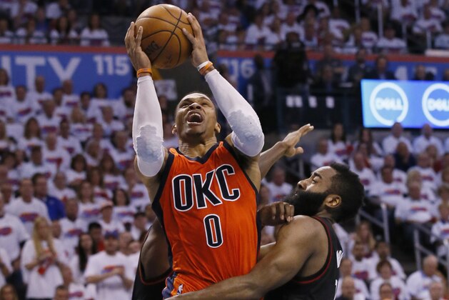 Oklahoma City Thunder guard Russell Westbrook (0) shoots between Houston Rockets guards Patrick Beverley, rear, and James Harden, right, in the fourth quarter of Game 4 of a first-round NBA basketball playoff series in Oklahoma City, Sunday, April 23, 2017. (AP Photo/Sue Ogrocki)