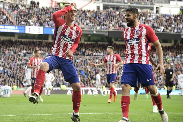 Atletico Madrid's French forward Antoine Griezmann (L) celebrates a goal during the Spanish league football match between Real Madrid CF and Club Atletico de Madrid at the Santiago Bernabeu stadium in Madrid on April 8, 2018. / AFP PHOTO / JAVIER SORIANO        (Photo credit should read JAVIER SORIANO/AFP/Getty Images)